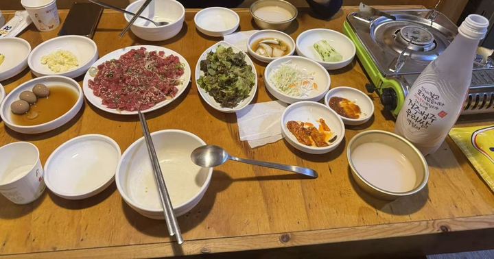 Yukhoe, side dishes and a bottle of rice makgeolli