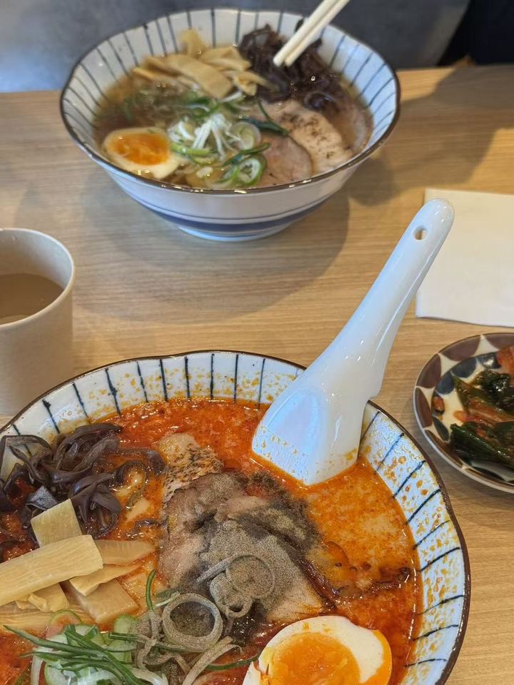 A bowl of spicy ramen and a bowl of shoyu ramen