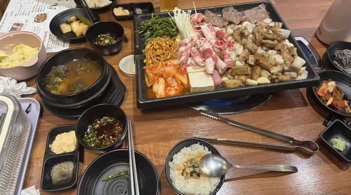 Beef intestines, meat rolls, kimchi and tofu on a griddle
